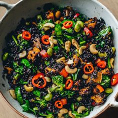 a bowl filled with black rice and vegetables