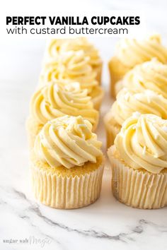 vanilla cupcakes with custard buttercream frosting on a marble surface