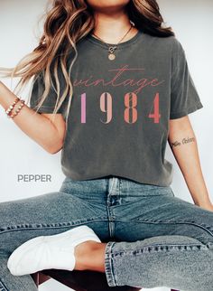 "Classic 1984 Shirts For Women, Vintage 40th Birthday Year Number Tshirt For Him, 40th Milestone Best Friend Bday Gift For Her, 40 Bday Shirt HOW TO ORDER ➀ Select color ➁ Select the size (Please check size chart) ✦ True to size. Size up 1-2 sizes for an oversized look. ➂ Add to cart ✦ (Optional) \"Add message to Seller\" on the checkout page. GARMENT FEATURES ✦ Crew neckline ✦ Direct to garment printing - no vinyl, decal, or iron-on technique ✦ Our designs are printed on the garment to last a long time and may not appear as 'glossy' or saturated as iron-on designs are. ✦ Please note that colors may appear different on different digital screens and may not be a true representation of the actual colors. ✦ Additional T-Shirt Colors and Sizes Available Upon Request ✧✧Brands: Bella Canvas Unis Babe Shirt, Number Shirt, Mama Shirts, Concert Shirts, Comfort Colors Tee, Comfort Color, Pullover Shirt, Nursing Shirts, Look Plus