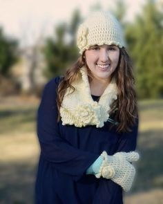 a woman wearing gloves and a knitted hat smiles at the camera while standing outside