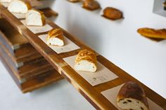 breads are arranged on wooden trays and lined up in rows with labels for them