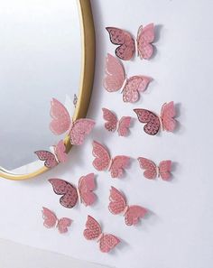 a mirror and some pink butterflies on the wall