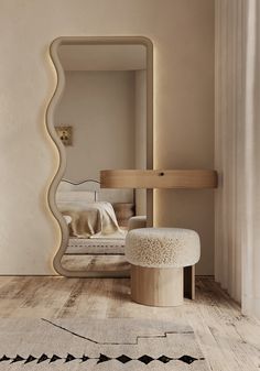 a mirror sitting on top of a wooden floor next to a white chair and ottoman