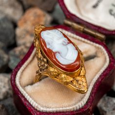 This vintage north-to-south cameo ring features a bezel set hard stone cameo with an elongated floral bezel. The ring is crafted in 14k yellow gold and has been re-shanked with 10k yellow gold. The ring also features a high carat gold wash with natural patina. Vintage 14k Gold Cameo Rings, Victorian Gold Cameo Rings, Victorian Cameo Rings For Anniversary, Cameo 14k Gold Ring, Collectible 14k Gold Cameo Rings, Cameo 14k Gold Rings For Collectors, Antique Cameo Signet Ring For Weddings, Cameo 14k Gold Rings For Anniversary, Gold Cameo Signet Ring Collectible