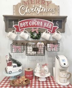 a hot cocoa bar with christmas decorations and coffee mugs hanging from the wall above it