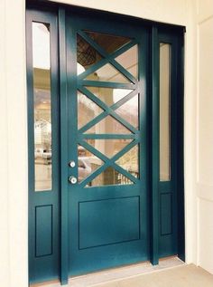 the front door is painted teal and has glass panels on each side, along with an arched window