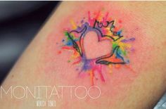 a colorful tattoo with a heart and crown on the back of someone's arm