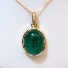 19.6ct Natural Colombian Emerald Pendant RRV: $17.500 This unique pendant is a handcrafted piece designed to make a statement. With 19.6 carats of natural Colombian emerald in a shiny oval cabochon that is of a deep green  like colour, the emerald is full bezel set in 18k gold and suspends from a yellow gold bail. The pendant is accompanied with a stamped 18ct chain. SPECIFICATIONS: 1982292 Gemstone: Oval cabochon Natural Colombian Emerald. Weight: 19.6ct. Measures: 17.8x13.8x9.7mm approx. Material: 18K yellow gold. Total Weight: 8.5 grams approx. Dimensions: 30.0x26.0mm approx. Chain: 18ct yellow gold. Certificate of Valuation : FGAA Gemmological Association of Australia and NCJV. We are a family owned business of gemologist, miners and dealers specialised in natural emeralds and colour g Elegant Oval Cabochon Emerald Necklace, Formal Hallmarked Emerald Necklace, Hallmarked Round Emerald Necklace, Luxury Oval Emerald Necklace, Luxury Oval Pendant Emerald Jewelry, Formal Green Jewelry With High Luster, Formal Emerald Pendant Necklace, Formal Green High Luster Jewelry, Classic Emerald Cabochon Jewelry