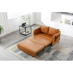 a brown leather sofa sitting on top of a rug