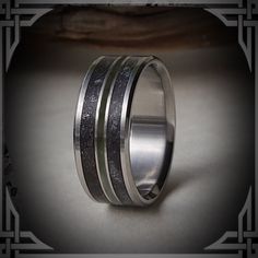 This ring is handmade from Titanium with Rear ; Fossilized Dinosaur Bone, B.C. Green Jade and Meteorite Inlay. The genuine materials we use are hand picked and crushed for all of our Inlays, no synthetics or dyes are used.   The aerospace, grade 5 Titanium is machined from solid stock, is hypoallergenic, extremely strong and light weight.  Available in all sizes and widths 7 to 9 mm.         The picture shows a size 10.5,  8 mm wide. We do our best to make your ring as close to the picture you o Engraved Titanium Jewelry For Weddings, Engraved Titanium Wedding Jewelry, Wedding Engraved Titanium Jewelry, Titanium Wedding Rings With Polished Finish, Wedding Titanium Rings With Polished Finish, Silver Titanium Wedding Rings, Silver Titanium Promise Jewelry, Titanium Silver Ring Jewelry, Modern Etched Jewelry For Wedding