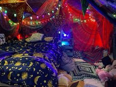 a bed with colorful lights hanging from it's sides and pillows on the floor