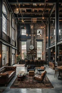 an industrial style living room with leather furniture and exposed ceiling beams, windows, and large clock on the wall