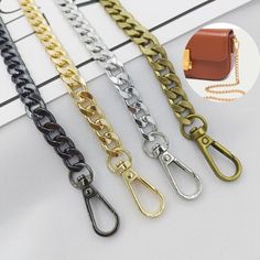 four different types of chain with clasps on each side and a small purse in the middle