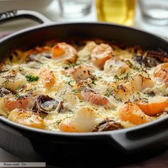 a close up of a casserole dish with shrimp and potatoes in it on a table