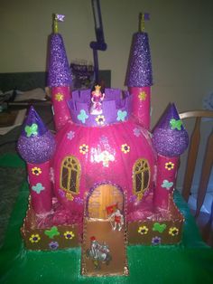 this is a cake that looks like a princess castle with lots of decorations on it