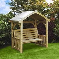 a wooden bench sitting in the middle of a lush green field next to some bushes