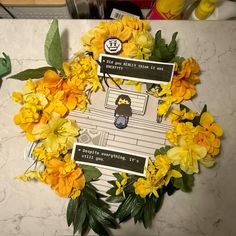 a bunch of yellow flowers sitting on top of a white marble counter next to green plants