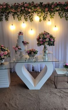 the table is decorated with pink flowers and greenery, along with two white heart shaped tables