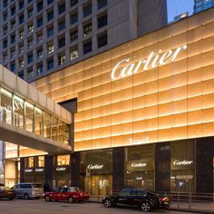 cars parked in front of a building with the word carrier lit up on it's side