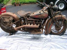 an old rusty motorcycle sitting on top of a tarp