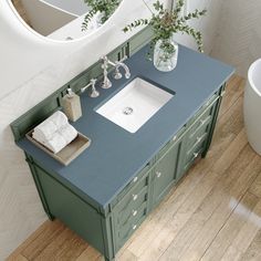 a bathroom vanity with blue counter top and white sink