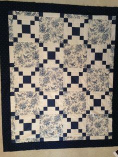 a black and white quilt is hanging on the wall