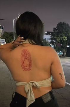 the back of a woman's body with tattoos on her upper and lower back