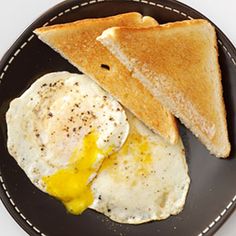 an egg and toast on a black plate