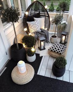 a porch decorated with potted plants and lights