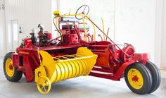 a red and yellow tractor parked in a garage