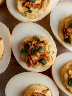 several deviled eggs with different toppings on them