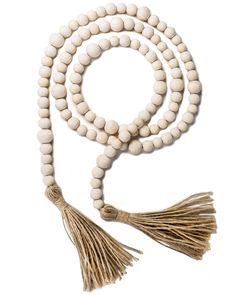 a white beaded necklace with tassels and a wooden cross on the end