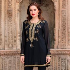 Sandip Agarwal of India designs this semi-sheer black polyester tunic that sparkles with hand embroidered embellishments. The hem sleeves and neckline are embroidered with alternating rows of gold-toned elongated faceted beads and round beads. The same beaded motif carries down the front of the tunic ending in a deep V. On the end of each sleeve on the center back and across the front are embroidered flowers embellished with beads and sequins. Luxury Dabka Embellished Women's Tunic, Luxury Embellished Tunic For Festive Season, Luxury Long Sleeve Embroidered Tunic, Luxury Embroidered Neckline Tunic For Eid, Luxury Long Sleeve Tunic With Embroidered Neckline, Luxury Resham Embroidery Festive Tunic, Luxury Long Sleeve Embellished Tunic, Luxury Embroidered V-neck Tunic, Maroon Gowns