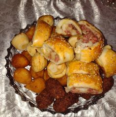 some rolls and tater tots are on a glass platter with silver foil