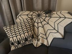 two crocheted spider webs are sitting on a couch next to a pillow