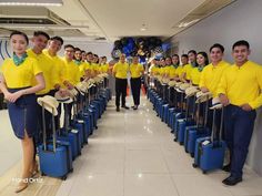 a group of people in yellow shirts and blue suitcases