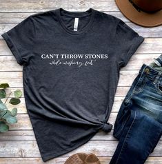 "\"Be the change you want to see in the world with our 'Can't Throw Stones While Washing Feet' shirt. A reminder that we should all be kind to one another, even when we disagree.\" 🕕Production Time 1-3 business day🕕 ➡️𝗛𝗢𝗪 𝗧𝗢 𝗢𝗥𝗗𝗘𝗥 ⬅️ 𝟏. Please, Check and Review all Photos. 𝟐. Select Your T-Shirt Size and T-Shirt Color from drop down menus. 𝟑. Enter your Design Color. 𝟒. Choose Your Quantity as much as you want. 𝟒. Click 𝗔𝗗𝗗 𝗧𝗢 𝗖𝗔𝗥𝗧. For multiple items go back to the lis Funny Cotton Tops With Quote Print, Cotton Short Sleeve Tops With Quote Print, Cotton Tops With Quote Print And Short Sleeve, Inspirational Crew Neck Top With Funny Text, Crew Neck Cotton Shirt With Quote Print, Cotton Crew Neck Shirt With Quote Print, Cotton T-shirt With Quote Print, Relaxed Fit, Relaxed Fit Cotton T-shirt With Quote Print, Inspirational Slogan Short Sleeve Shirt