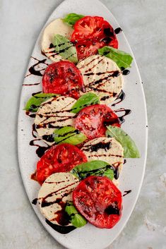 grilled tomatoes and mozzarella with balsami sauce on a white plate