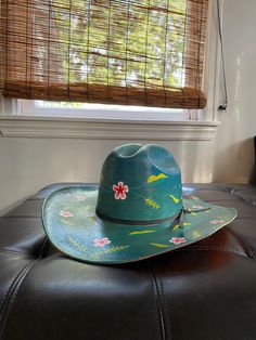 The Femininomenon Hat!  Get it hot like Papa John with this one of a kind handpainted floral cowboy hat!  It is an upcycled Tucson Hat- 6-7/8. Green Western Hats For Spring, Green Western Style Hats For Spring, Green Western Hat Bands For Summer, Green Western Fedora For Summer, Green Summer Western Fedora, Green Summer Hat For Rodeo, Fun Hat With Curved Brim For Country Events, Fun Curved Brim Hat For Kentucky Derby, Adjustable Fun Hat For Western-themed Events