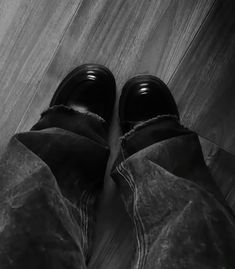 black and white photograph of someone's shoes on the floor in front of them