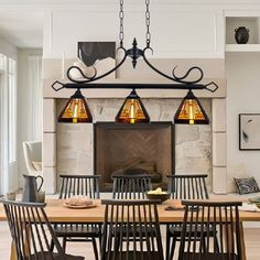 a dining room table with four chairs and a fire place in the fireplace behind it