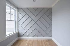 an empty room with wood flooring and white painted walls, along with a window