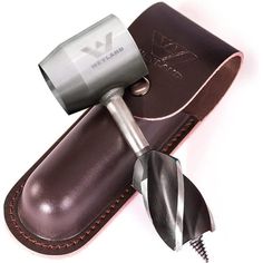 a hair dryer sitting on top of a leather case next to a razor blade