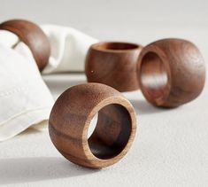 three wooden rings sitting next to each other on a white tablecloth and napkins