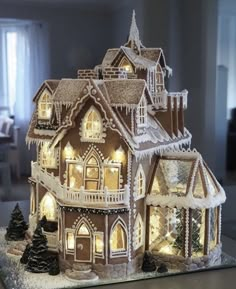 a lighted gingerbread house with snow on the roof