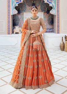 Description: The magic of this outfit with engaging embellishments on an orange hue is what makes Kesar an eye-catching outfit. The orange rawsilk choli is adorned in gold tones with intricately crafted embellishment. This contemporary combination has highlighted kiran lace accents on the borders of dupatta, which are Bridal Lehengas Indian, Mendhi Outfit For Bride, Wedding Dress Lehenga, Kanwal Malik, Dress Lehenga, Pakistani Bridal Lehenga, Latest Lehenga Designs, Orange Lehenga, Choli Dress