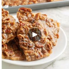 a white plate topped with cookies covered in nuts