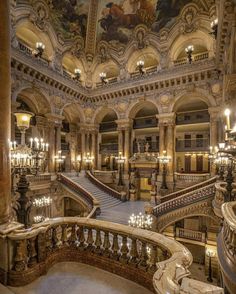 an ornate building with chandeliers and paintings on the walls