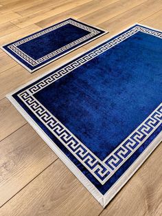 two blue rugs sitting on top of a hard wood floor next to each other