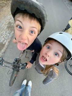 two young children on bicycles making funny faces